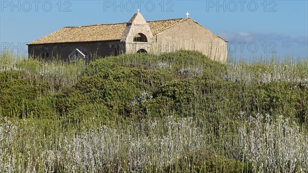 Old church on a green hill surrounded by wild grasses and a clear sky in the background, sea fortress Methoni, Peloponnese, Greece, Europe