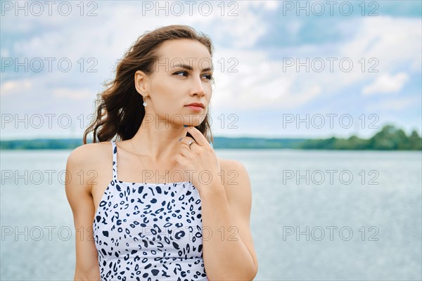 Portrait of cute woman touching her chin at lake