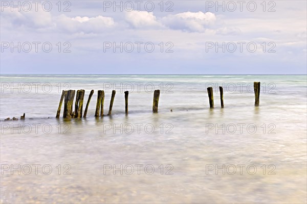 Long exposure of an almost dilapidated wooden groyne on the Baltic Sea with soft colours
