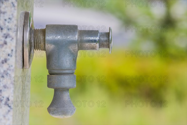 Closeup of water faucet on marble water fountain in public park in South Korea