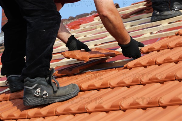 Roofer covering a heritage-protected tiled roof