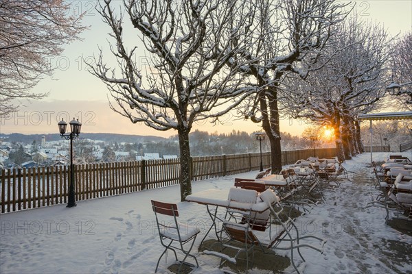 Snow-covered beer garden in winter, sunset, Andechs Monastery, Fuenfseenland, Pfaffenwinkel, Upper Bavaria, Bavaria, Germany, Europe
