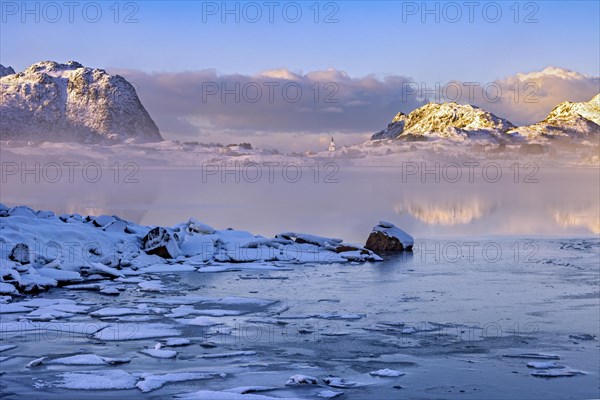 Eisige Landschaft mit Eisplatten im Fjord und einem idyllischen Dorf in den verschneiten Berglandschaft auf den vesteralen