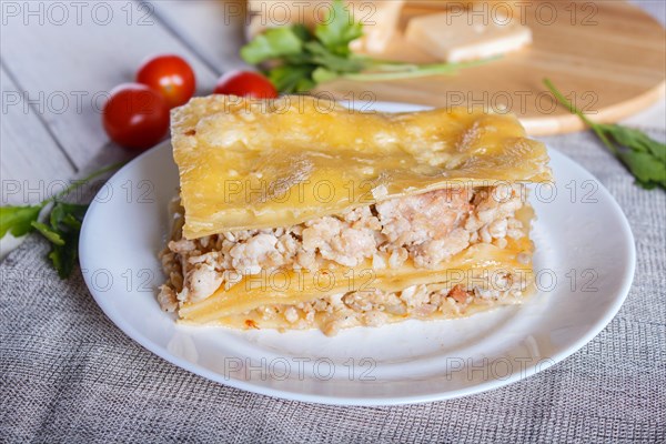 Lasagna with minced meat and cheese on white wooden background. close up