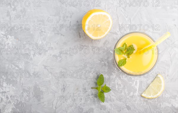 Glass of lemon drink on a gray concrete background. Morninig, spring, healthy drink concept. Top view, copy space, flat lay