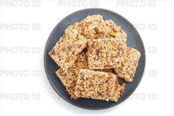 Homemade granola from oat flakes, dates, dried apricots, raisins, nuts in blue ceramic plate isolated on white background. top view, flat lay, close up, macro