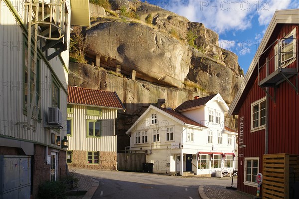 Small houses huddled under high rocks, Archipelago coast, Fjaellbacka, Vaestra, Goetlands, Sweden, Europe