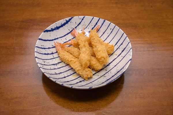Shrimp tempura on a plate placed against a black background. Tempura is a Japanese food. It is Japanese fried shrimp Majorca, Balearic Islands, Spain, Europe