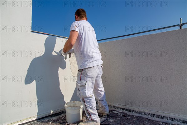 Plasterer plasters the facade of a new building