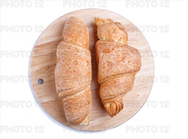 Two croissants on wooden kitchen board isolated on white background. top view