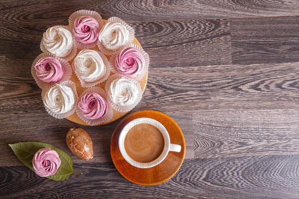 Pink and white homemade marshmallows (zephyr) with cup of coffee on a gray wooden background. top view, copy space