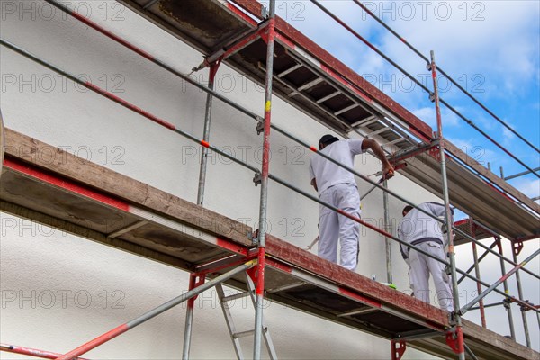 Painter painting the facade of a new residential building