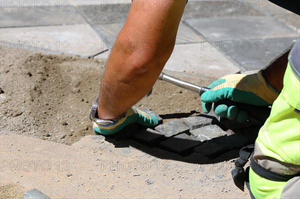 Worker lays paving stones