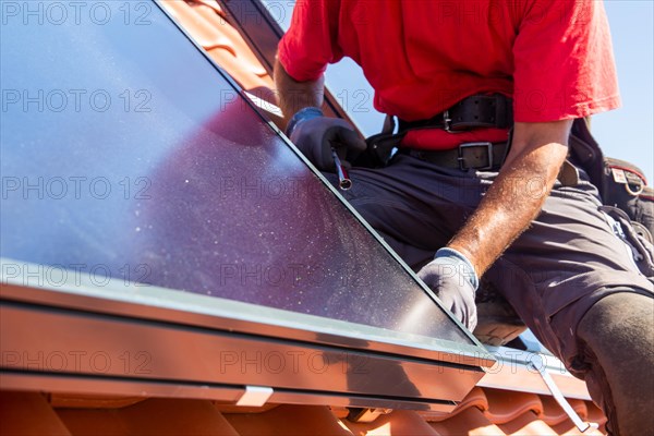 Installation of solar collectors for solar thermal energy. The company Hanschke Solarmontagen installs solar panels on a newly built apartment block in Mutterstadt (Palatinate)