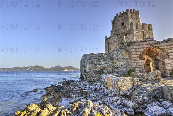 HDR photo of an old castle on the coast with blue sky and mountains in the background, octagonal medieval tower. Islet of Bourtzi, sea fortress Methoni, Peloponnese, Greece, Europe