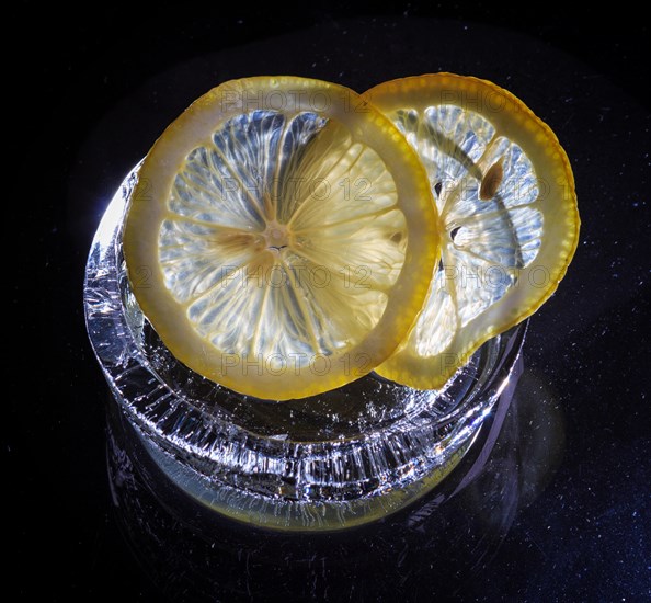 Transparent slices of fresh oranges and lemons on the glass with ice