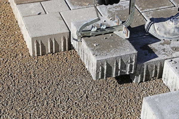 Workers lay paving stones