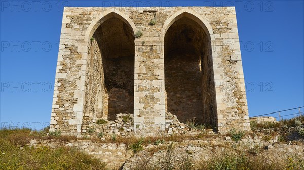 Two large arched windows in an old stone wall with a view of the blue sky, sea fortress of Methoni, Peloponnese, Greece, Europe