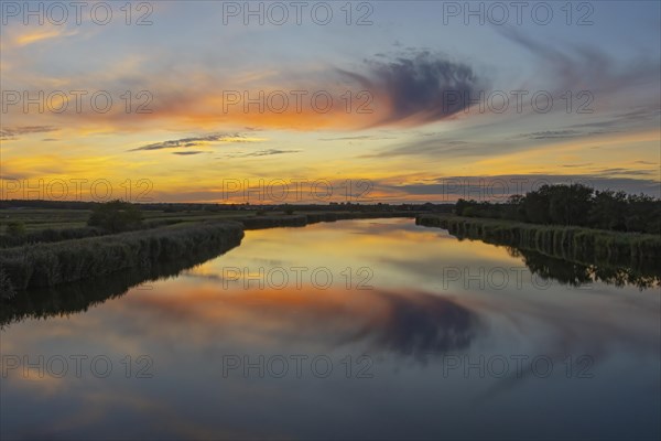 Ride in the most beautiful evening light with a brilliant reflection in the water of the Bodden near Prerow on the Darss