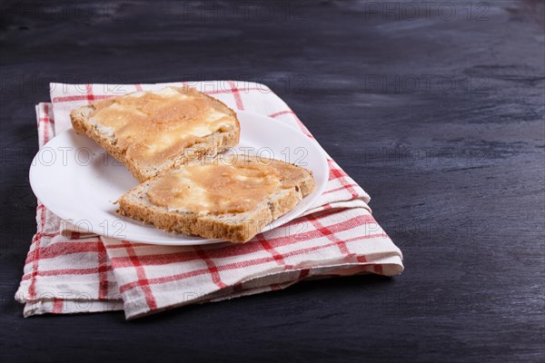 Sandwiches with pollock roe on a white plate, on a black background, with copy space