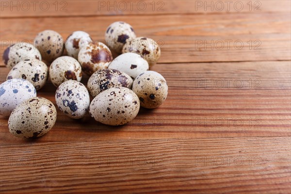 Raw quail eggs on a brown wooden background. with copy space
