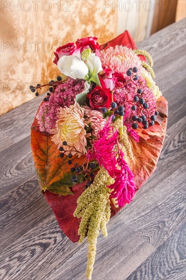 Bouquet of autumn flowers on a frame on a wooden background. floristic composition