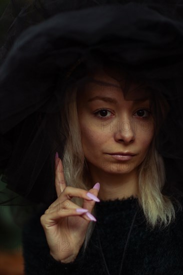 Moody portrait of a woman with a contemplative expression making a hand gesture