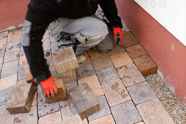 Worker lays paving stones