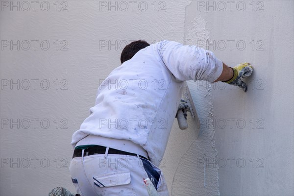 Plasterers plaster the facade of a new building (Mutterstadt development area, Rhineland-Palatinate)