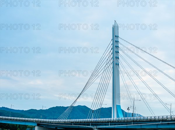 Modern suspension bridge against a cloudy blue sky, symbolizing engineering and transportation, in South Korea