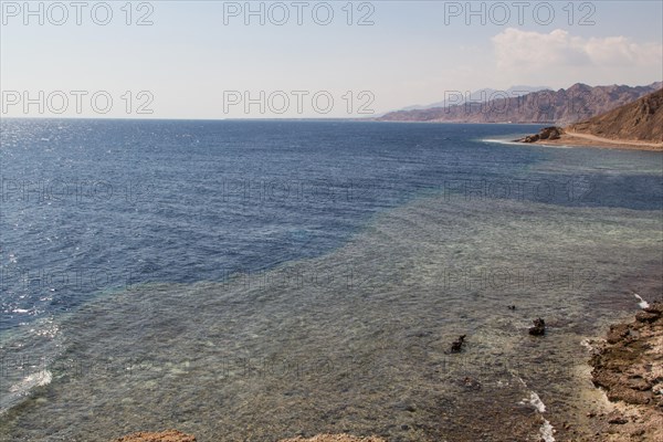 The coastline of the Red Sea with small resorts and the mountains in the background. Coral reef Blue Hole. Egypt, the Sinai Peninsula, Dahab