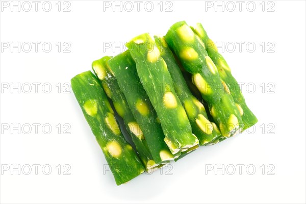 Green traditional turkish delight (rahat lokum) with peanuts isolated on white background. top view, flat lay, close up