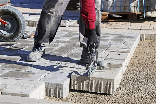 Workers lay paving stones