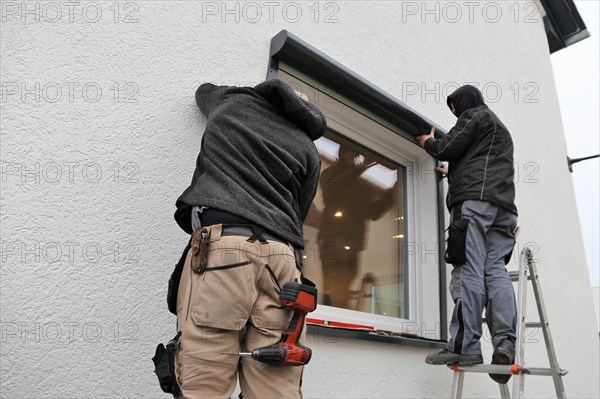 Craftsmen install a front-mounted roller shutter