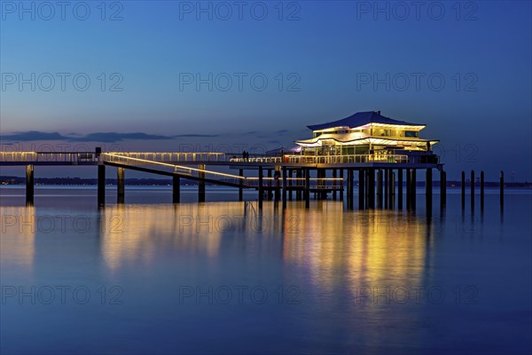 Blue hour at the illuminated Mikado house on the beach of Timmendorf on the Baltic Sea as a long exposure