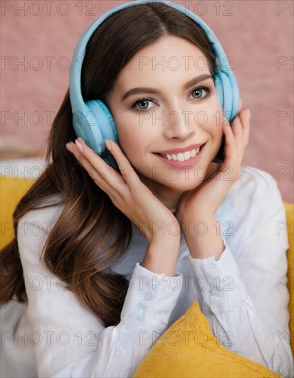 AI generated, human, humans, person, persons, woman, woman, girl, 20, 25, years, one person, interior shot, sitting on the sofa and listening to music with headphones, relaxed, relaxed, light blue headphones, beautiful teeth, beautiful eyes, smiling, happy