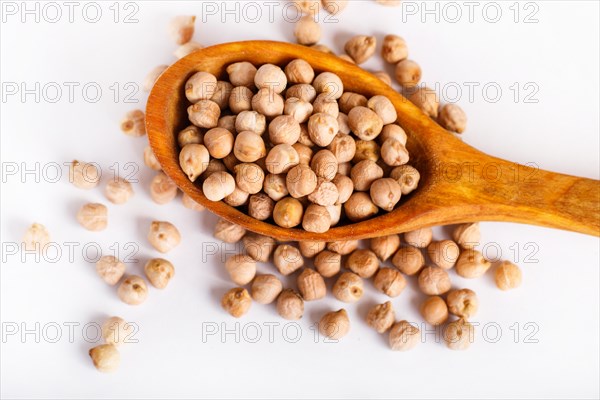 Pile of chickpeas in a wooden spoon isolated on white background