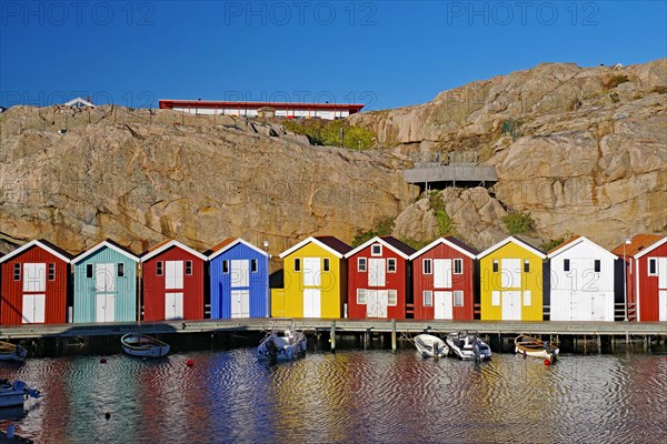 Colourful fishermen's huts nestled against high cliffs, archipelago coast, Smoegen, Vaestra Goetalands Laen, Sweden, Europe