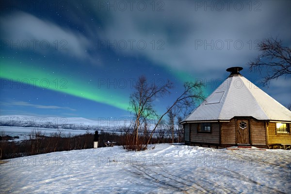 Northern Lights (aurora boreailis) over a small wooden hut in Swedish Lapland, Abisko, Kiruna, Sweden, Europe