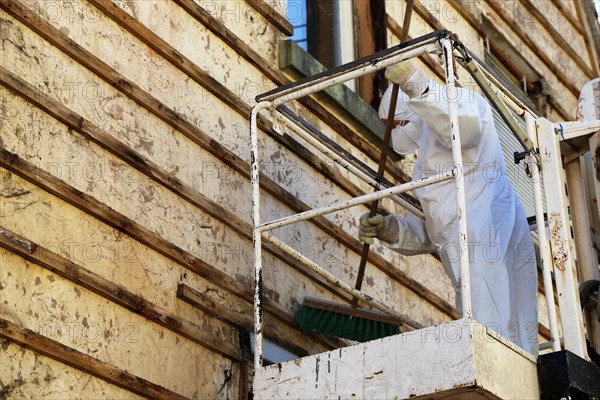 Professional asbestos removal by workers in protective suits