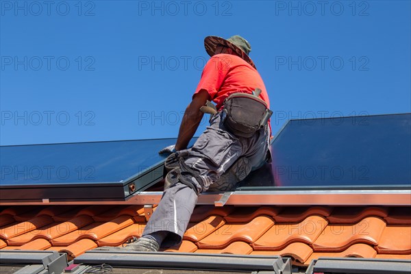 Installation of solar collectors for solar thermal energy. The company Hanschke Solarmontagen installs solar panels on a newly built apartment block in Mutterstadt (Palatinate)