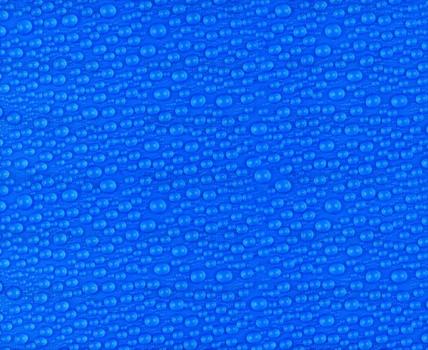 Many small water drops on a blue surface