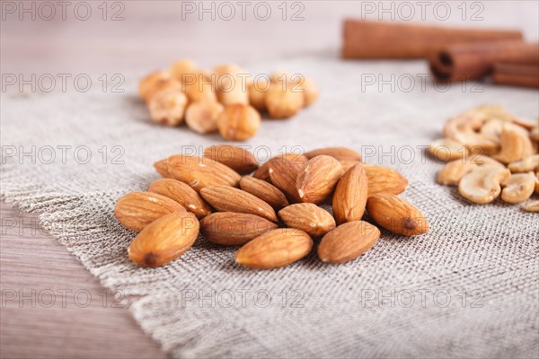 Cinnamon, almonds, hazelnuts, cashew on a linen napkin. Still life. Closeup