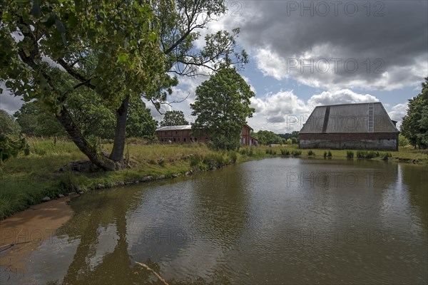 Pig and poultry barn with extinguishing pond on an old estate, Othenstorf, Mecklenburg-Vorpommern, Germany, Europe