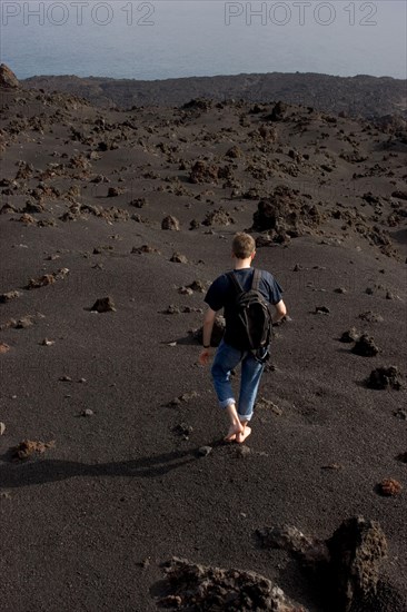Walking barefooted over volcanic sand of the Teneguia volcano, La Palma, Canary Islands, Spain, Europe