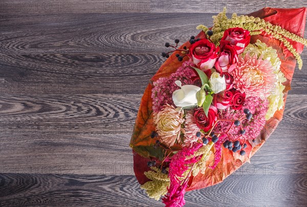 Bouquet of autumn flowers on a frame on a wooden background. floristic composition