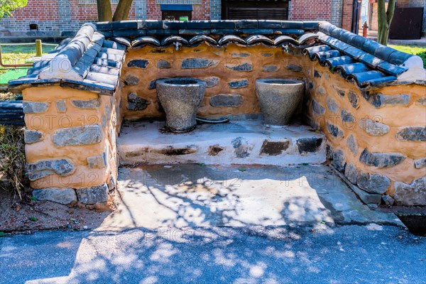 Public water fountains in alcove of mud and stone with ceramic tiled walls in South Korea