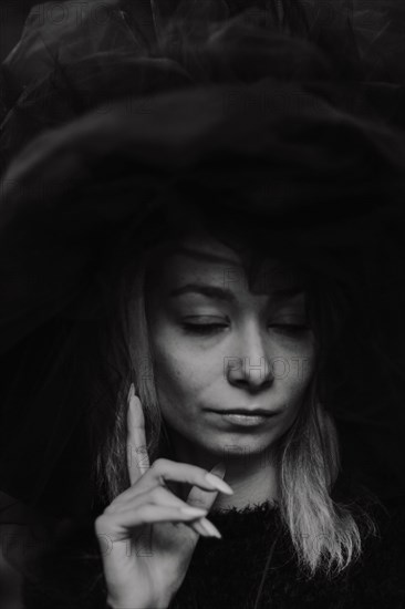 Black and white image capturing a woman's thoughtful expression in a close-up portrait
