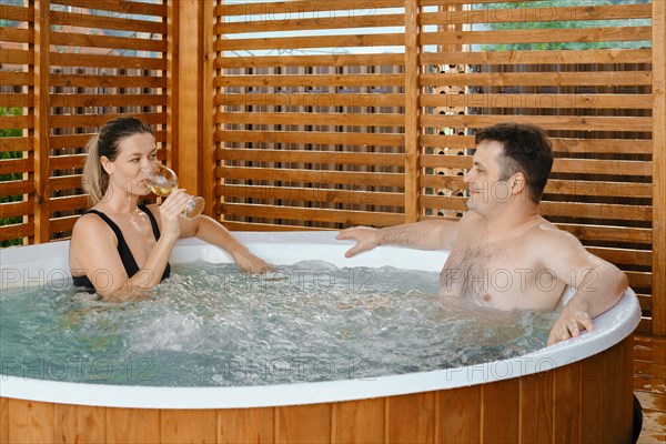 Couple in love spending time together in outdoor hot tub enjoying free time