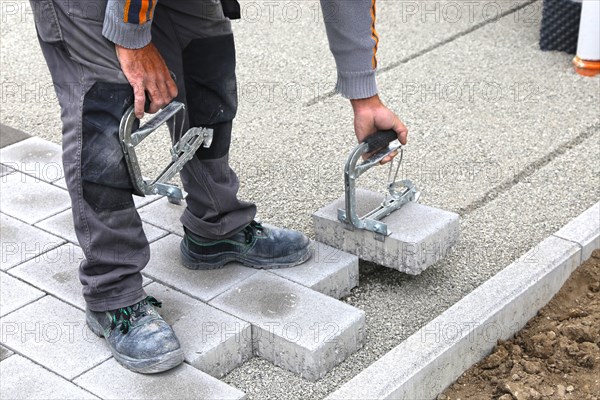 Worker lays paving stones